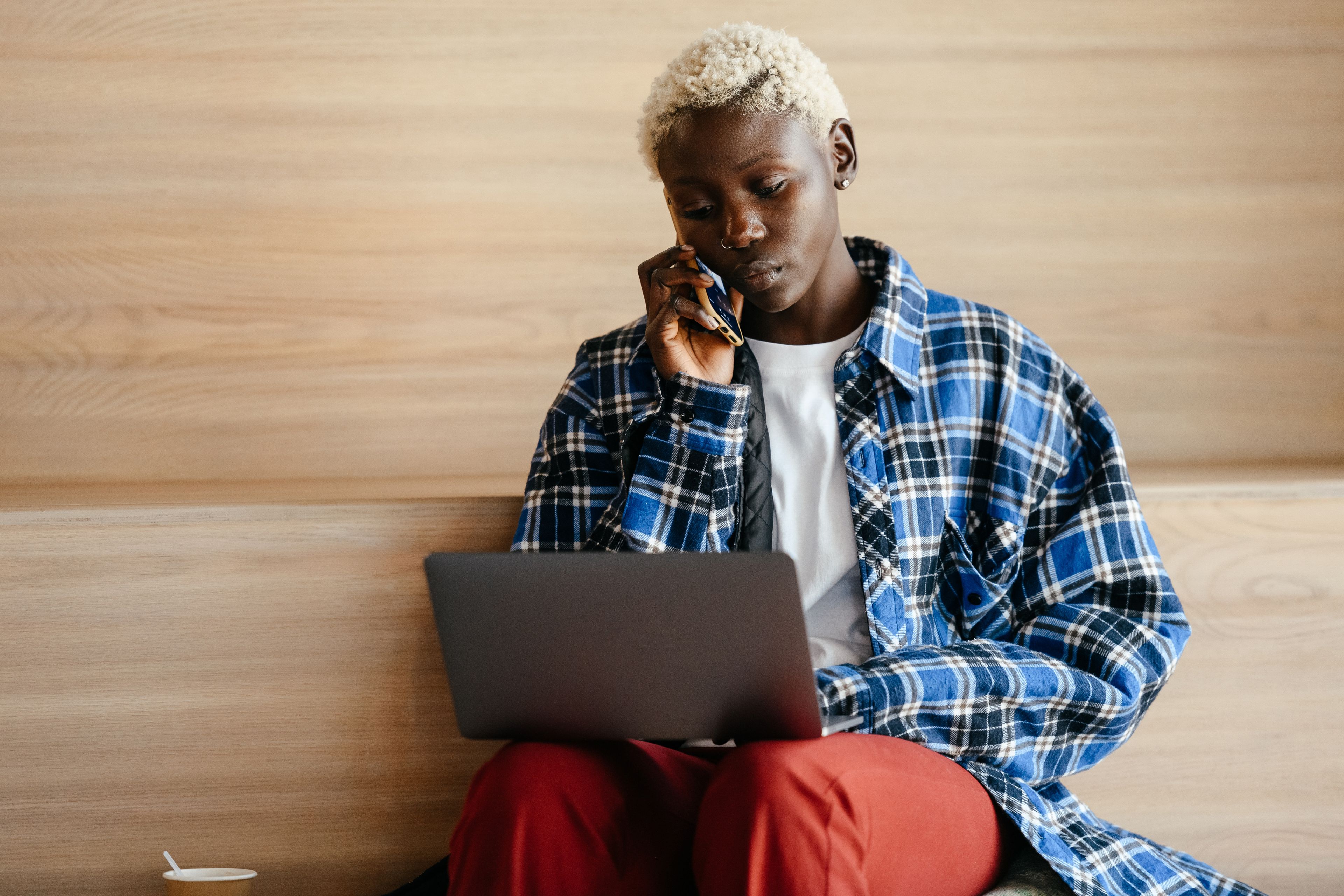 A woman preparing with her phone and laptop